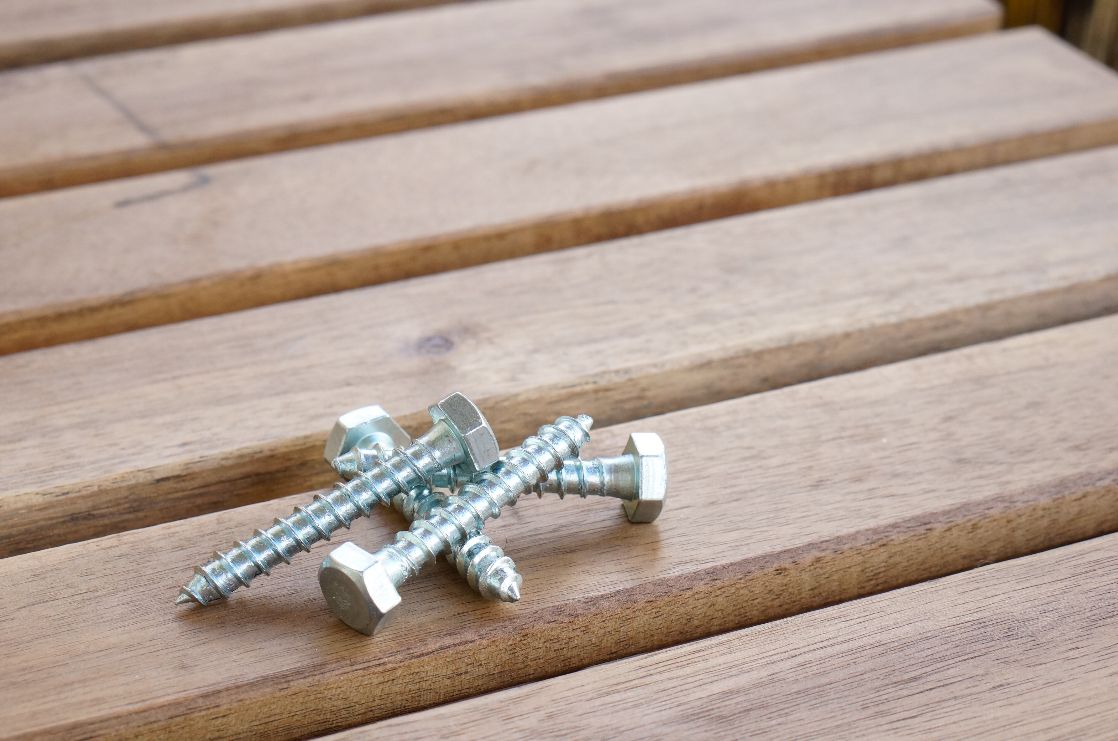 high-angle-closeup-shot-of-screws-on-a-wooden-table.jpg